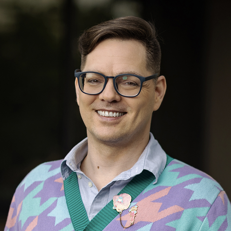 Portrait of AJ Durand, a man with short dark blonde hair.